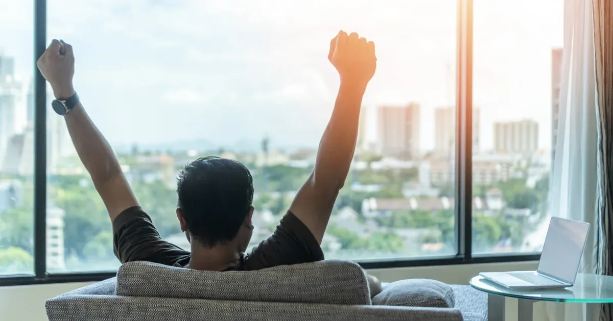 Men celebrating with view from the high rise apartment after achieving a data annotation Certificate from DeeLab Academy.